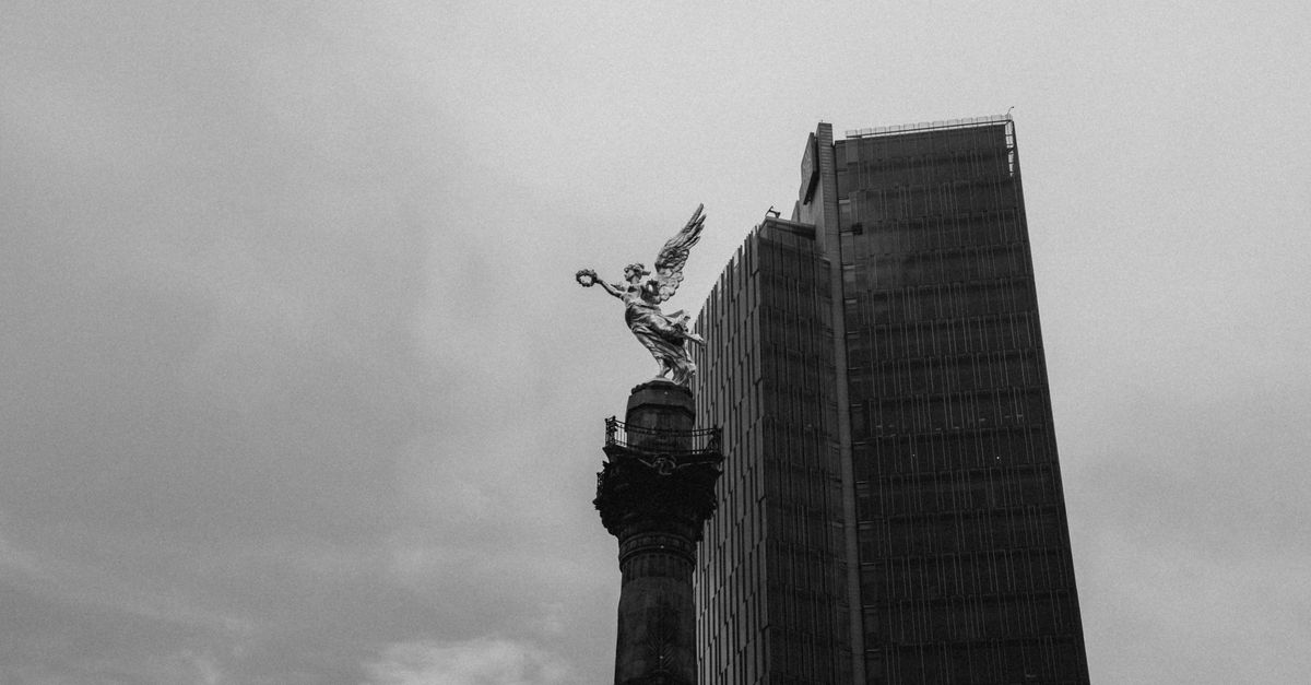Black and white view of Angel of Independence with skyscraper in Mexico City.