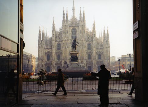 A captivating view of Milan Cathedral with silhouettes of people walking in the foreground.
