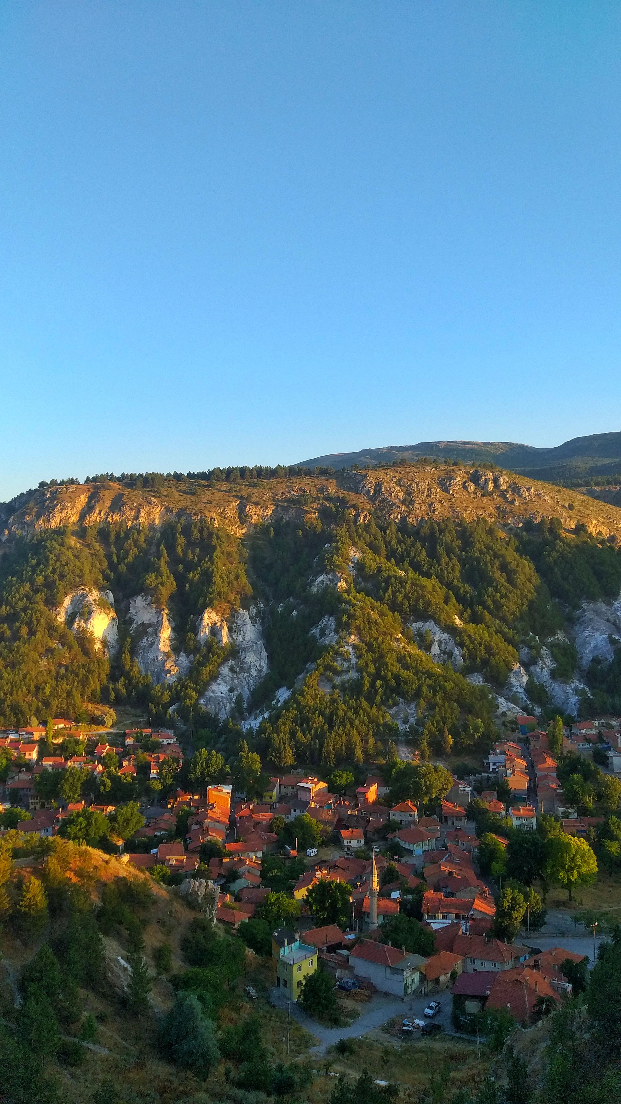 A beautiful aerial view of a hillside village in Kütahya, Türkiye during a sunny day.