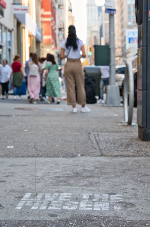 Free Busy New York street scene with 'Live the Present' graffiti inspiring passersby. Stock Photo