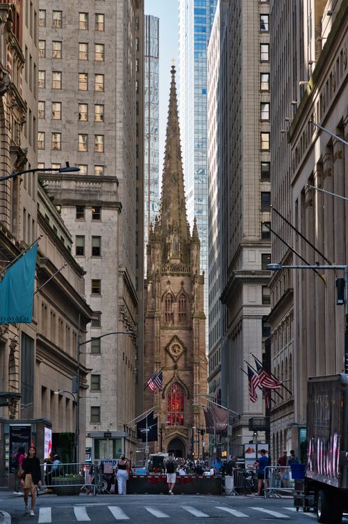 Free Iconic Trinity Church framed by towering skyscrapers in New York City, blending historic and modern architecture. Stock Photo