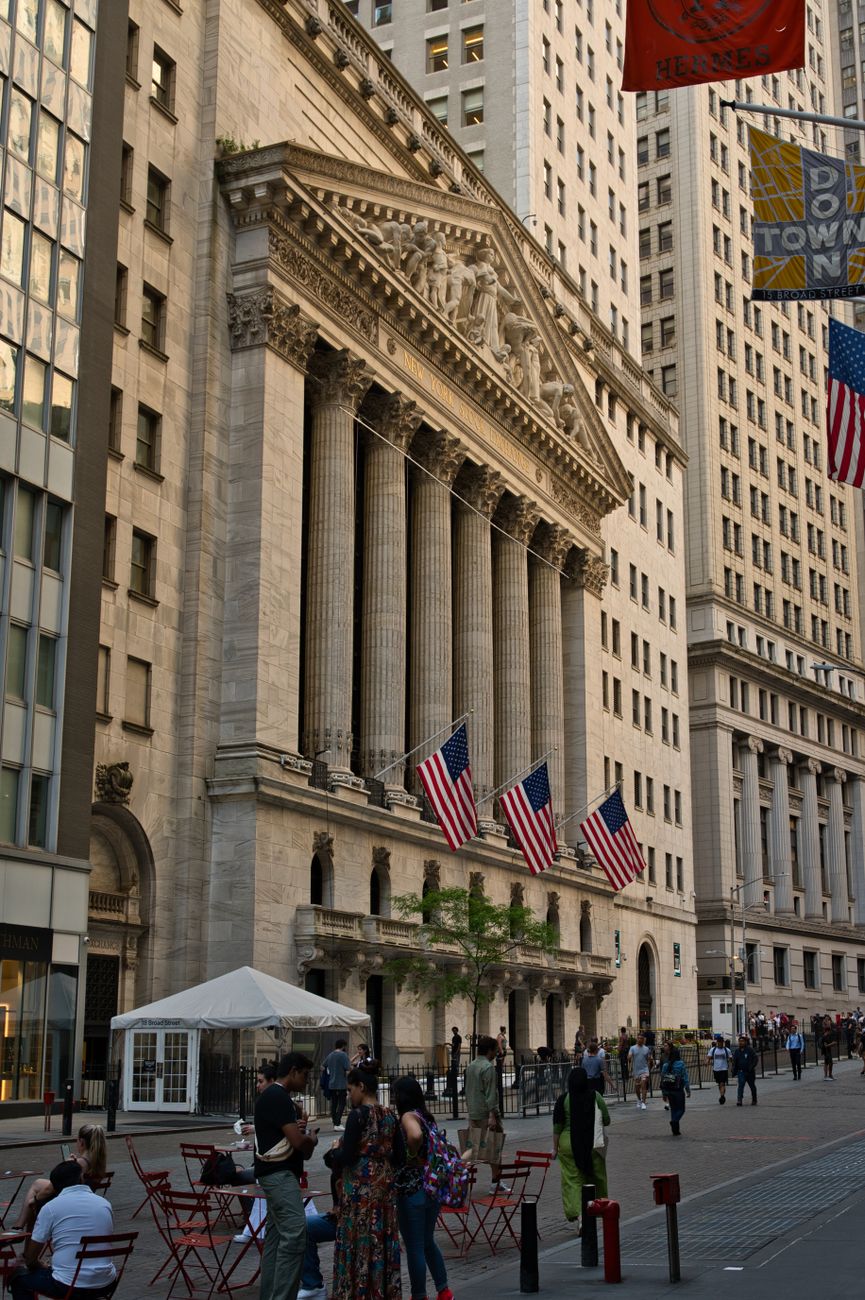 Pedestrians pass the New York Stock Exchange on Wall Street ahead of second-quarter bank earnings season.