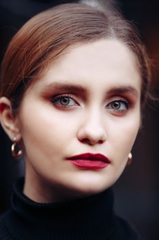 Close-up portrait of a woman with striking eyes and bold makeup, emphasizing elegance and beauty.