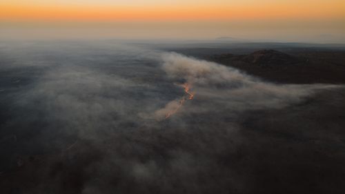 Free Dramatic aerial view of fire and smoke over a South African landscape at sunset. Stock Photo