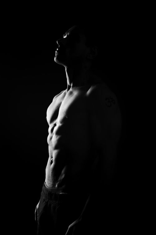 Free Artistic black and white portrait of a shirtless man in profile with dramatic lighting. Stock Photo