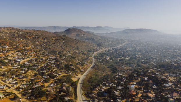 Aerial photograph capturing expansive rural landscape near eSwatini border, showcasing winding road through hills.
