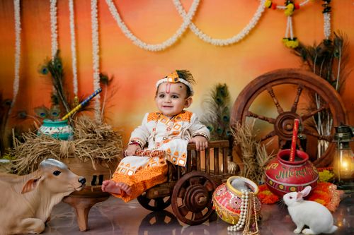 Free Adorable baby dressed as Lord Krishna with cultural ornaments and props, celebrating Janmashtami. Stock Photo