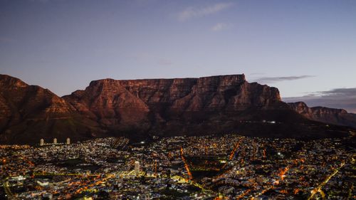 Free A breathtaking aerial view of Cape Town at dusk with the iconic Table Mountain backdrop. Stock Photo