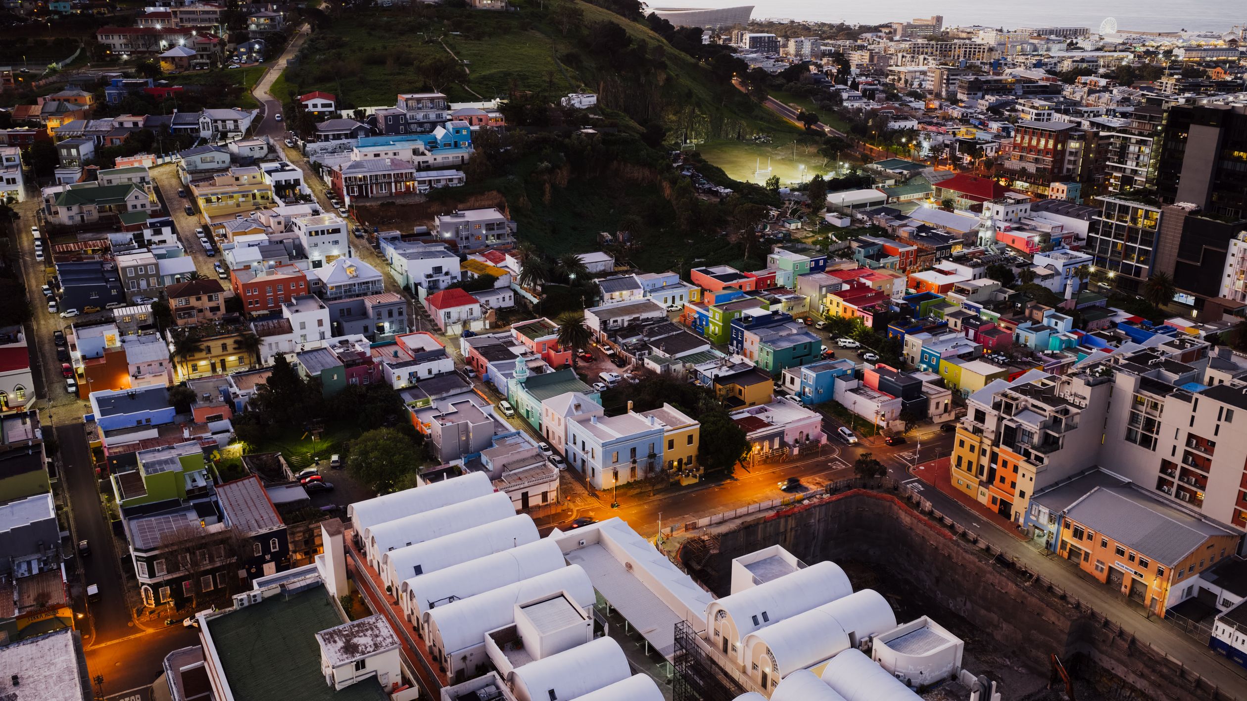 Stunning aerial view of Bo-Kaap, Cape Town with colorful houses illuminated at dusk, showcasing urban landscape