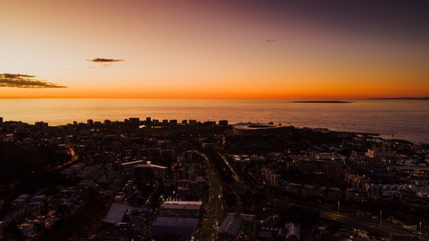 Stunning aerial view of Cape Town cityscape during sunset with ocean horizon in the background.