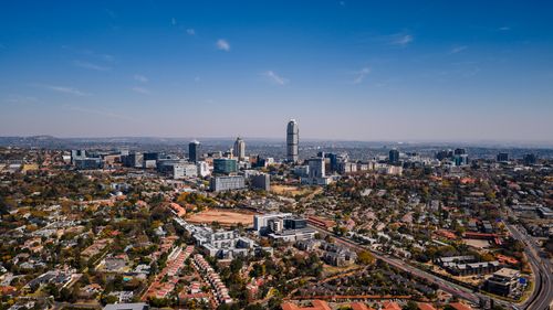 Free Aerial shot capturing the bustling urban skyline of Sandton in Gauteng, with its mix of modern skyscrapers and suburban areas. Stock Photo
