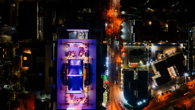 Vibrant aerial night view of Sandton showcasing illuminated rooftops and streets in South Africa.