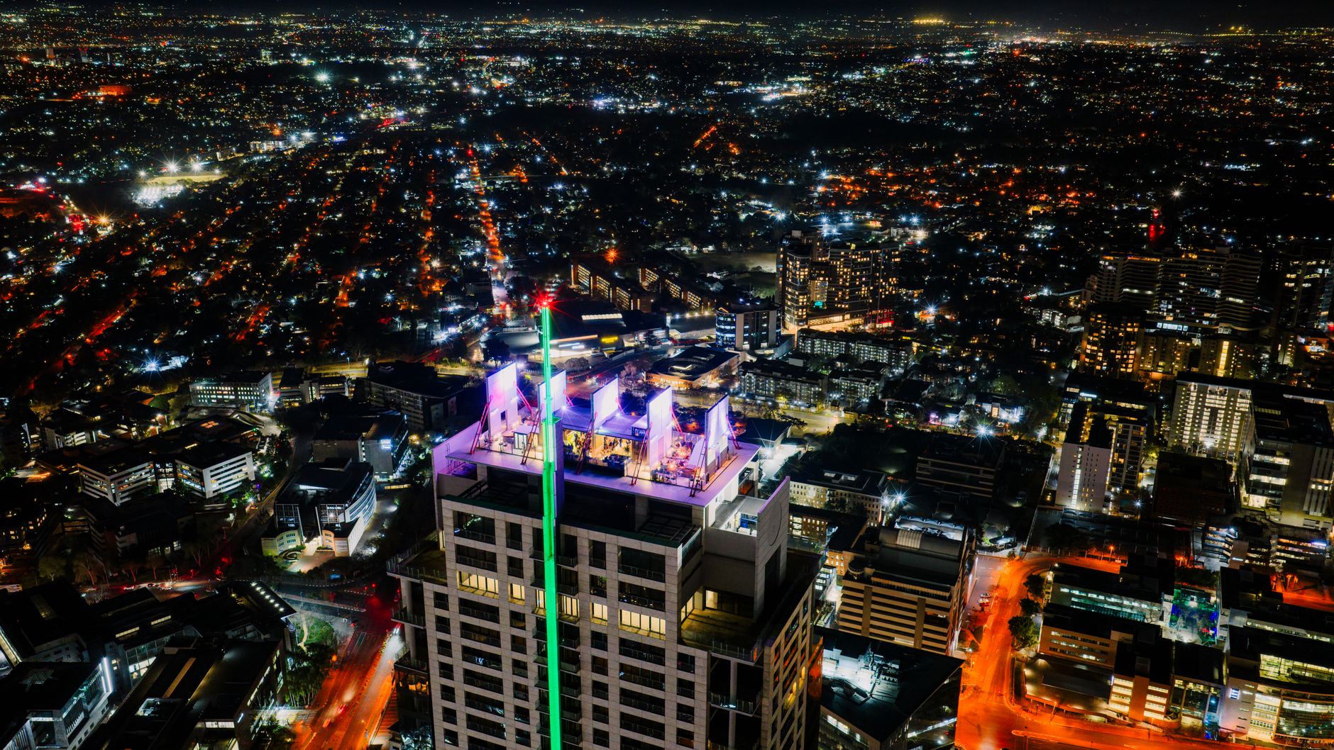 Stunning aerial view of Sandton, Gauteng illuminated at night, showcasing cityscape and architecture.