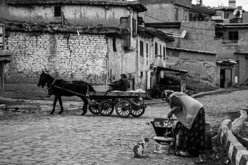 Free Black and white photo capturing a horse carriage and locals on a rustic street in Afyonkarahisar, Türkiye. Stock Photo