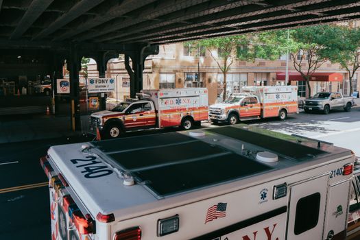 FDNY ambulances lined up under an overpass in New York City, USA, near Station 7.