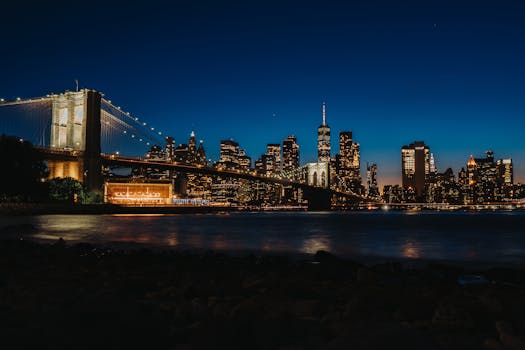 Breathtaking night skyline of New York City featuring iconic Brooklyn Bridge and modern skyscrapers.