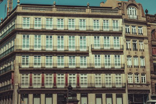 Free Vintage style photo of a historic European building facade featuring multiple balconies and ornate windows. Stock Photo
