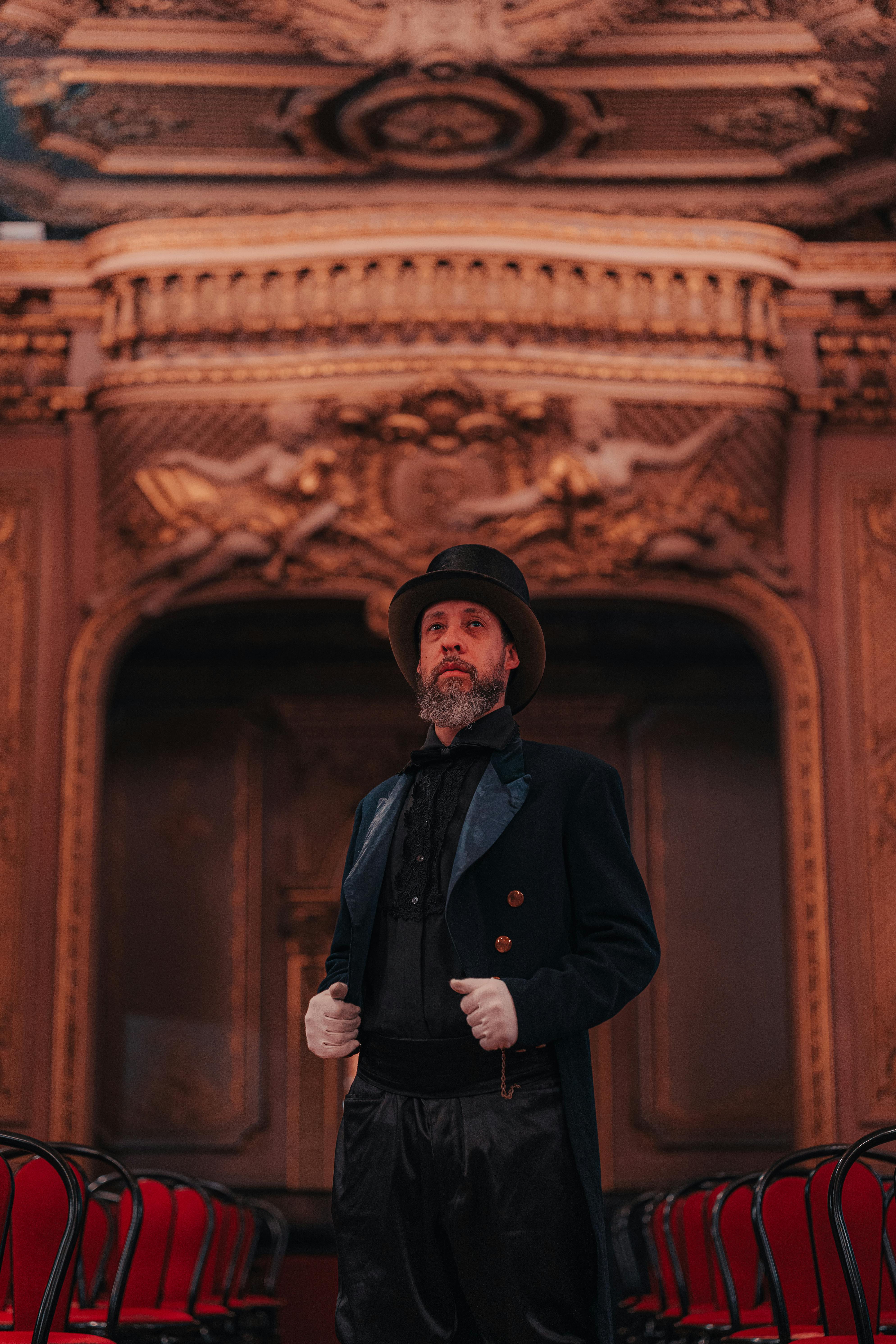 Ücretsiz Viktorya dönemi kostümü giymiş bir adam, klasik modayı sergileyen zengin dekorasyonlu gösterişli bir odada duruyor. Stok Fotoğraflar