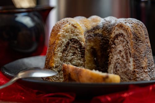 Free Enjoy a slice of warm, festive homemade marble bundt cake dusted with sugar icing, perfect for dessert. Stock Photo