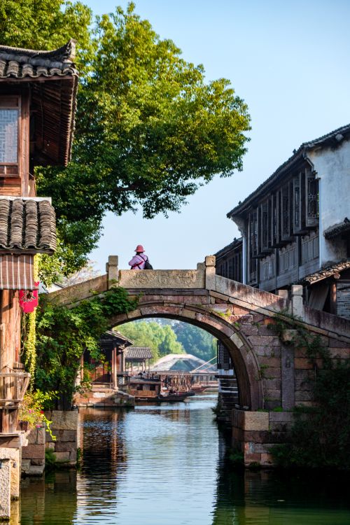 Free Scenic view of a traditional stone bridge in a picturesque ancient Chinese water town setting. Stock Photo