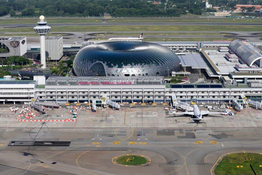 Aerial view of Singapore Changi Airport, showcasing modern architecture and bustling airport activity.