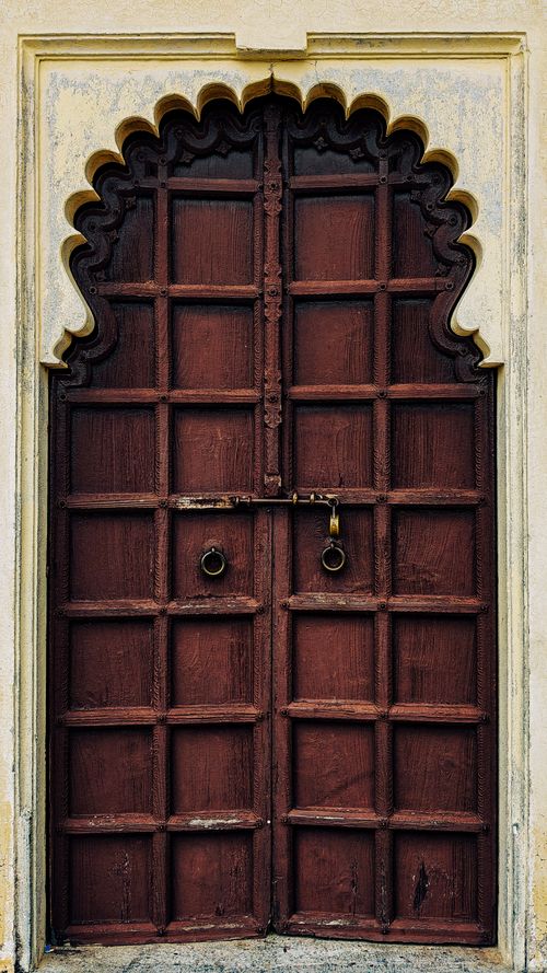 Free Intricately designed wooden door with arch in Udaipur's heritage architecture. Stock Photo