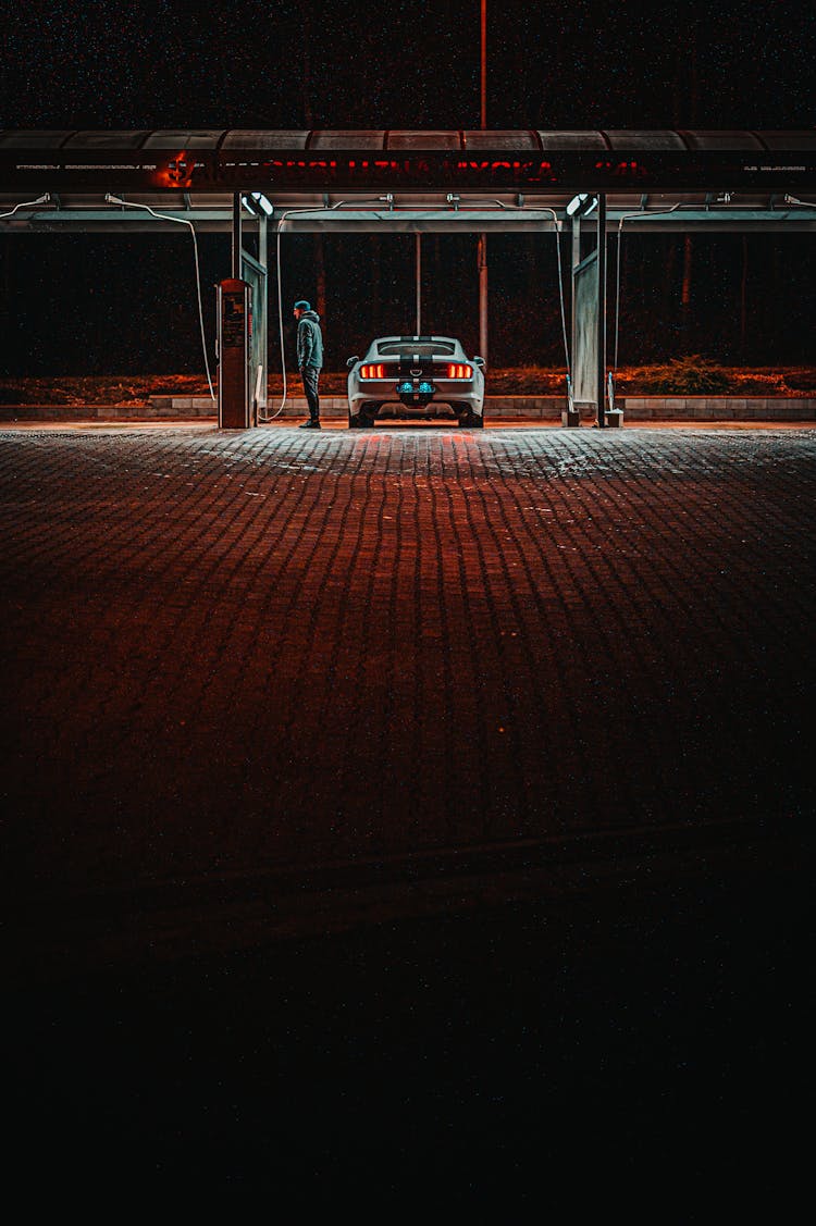 Man Standing Next To A Car At Gas  Station