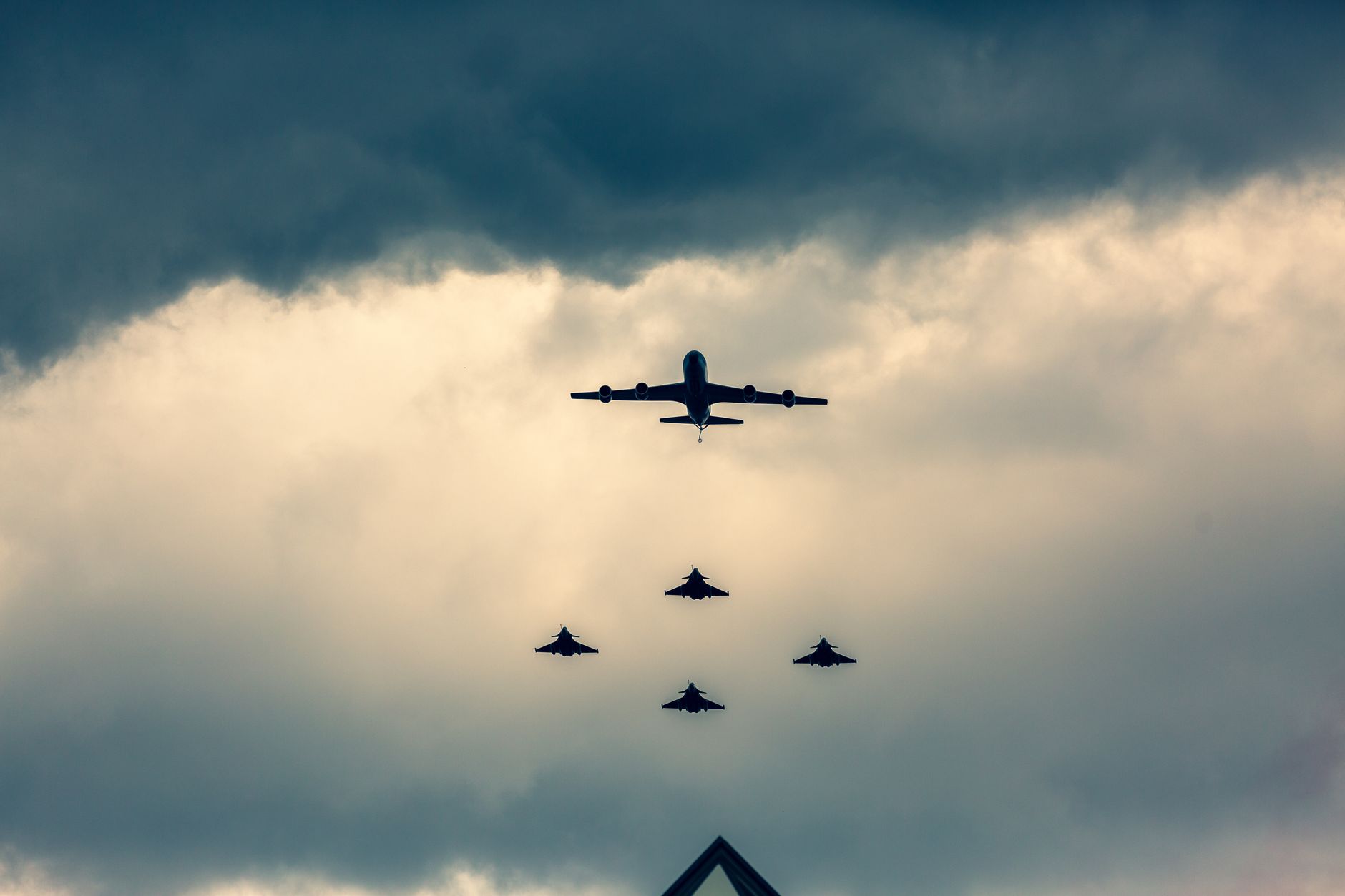 Stunning aerial view of military jets in formation during flight maneuvers against a dramatic sky.