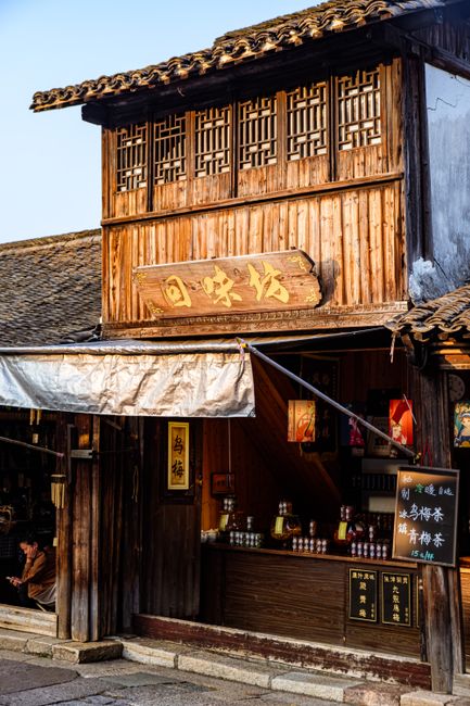 Scenic view of a traditional wooden shop in a historic Chinese village with wooden architecture.
