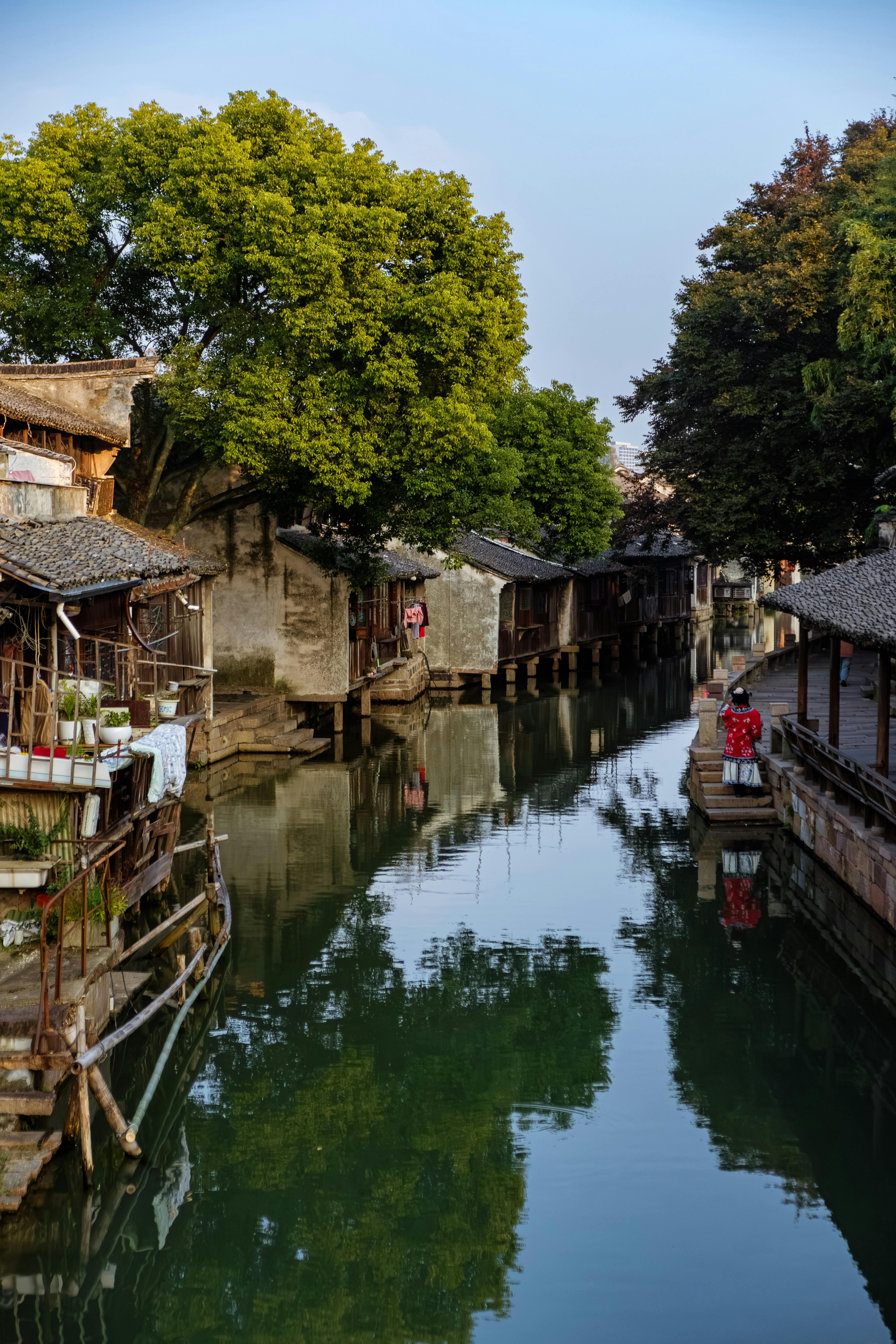 Picturesque riverside village in China with traditional architecture and serene canal.