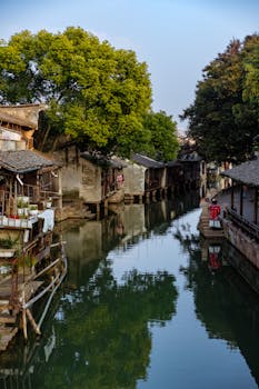 Picturesque riverside village in China with traditional architecture and serene canal.