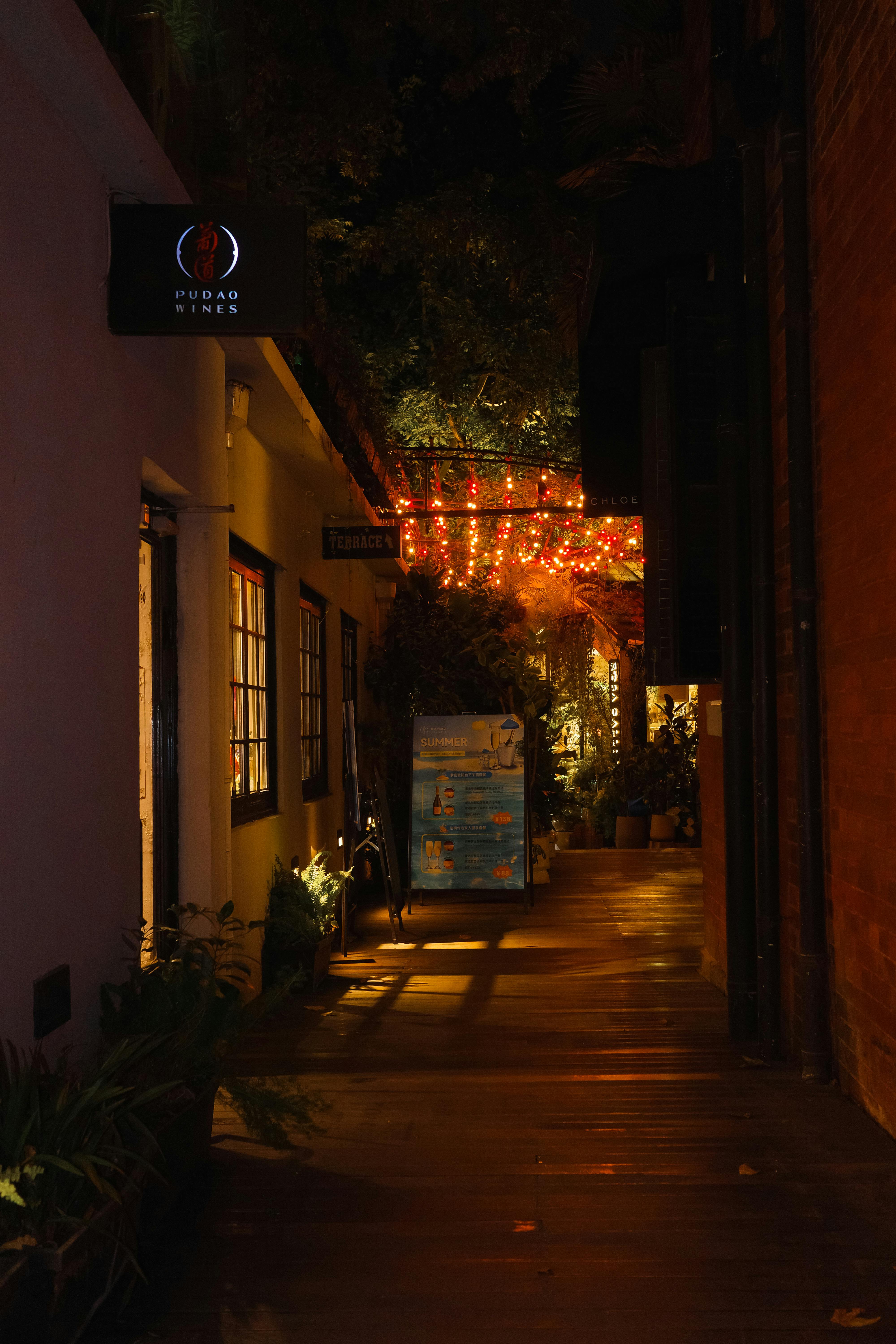 Gratuit Alee confortabilă, iluminată noaptea de luminițe calde, care emană un farmec urban liniștit. Fotografie de stoc