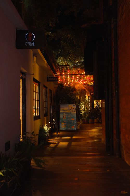 Free Cozy alleyway illuminated by warm string lights at night, exuding a peaceful urban charm. Stock Photo