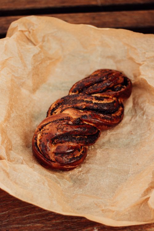 Free Freshly baked braided chocolate pastry on parchment paper in a rustic setting. Stock Photo