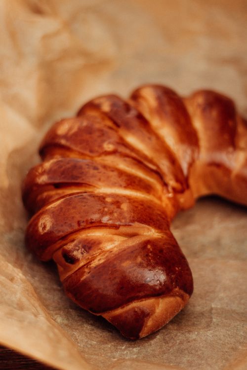 Free Freshly baked, golden brown pastry resting on parchment paper, showcasing a delicious and inviting appearance. Stock Photo