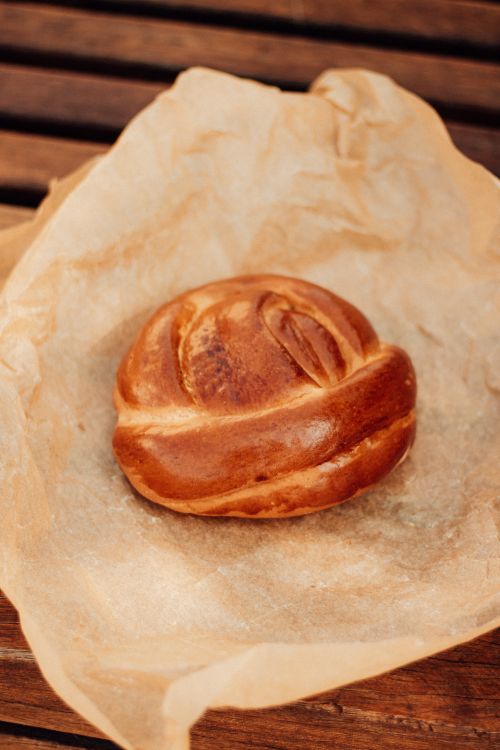 Free Golden homemade bread on parchment with a warm rustic feel, ideal for baking themes. Stock Photo