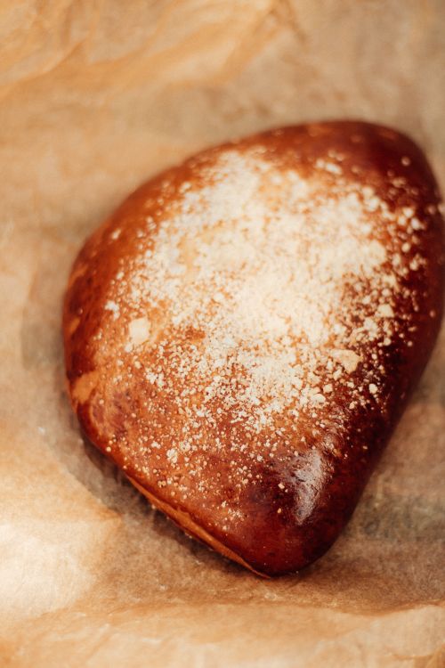 Free Close-up of a homemade sweet pastry sprinkled with flour on baking paper. Stock Photo