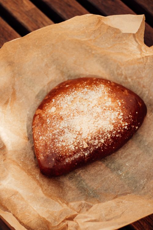 Free A close-up of a freshly baked, rustic sweet bread on parchment paper. Stock Photo