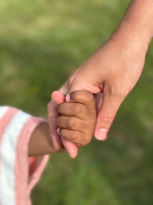 Free Tender connection between adult and child holding hands outdoors. Stock Photo