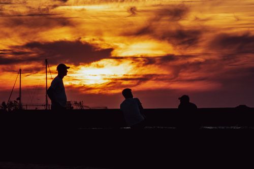 Free Dramatic sunset silhouettes of people at Yalova harbor, Türkiye. Stock Photo