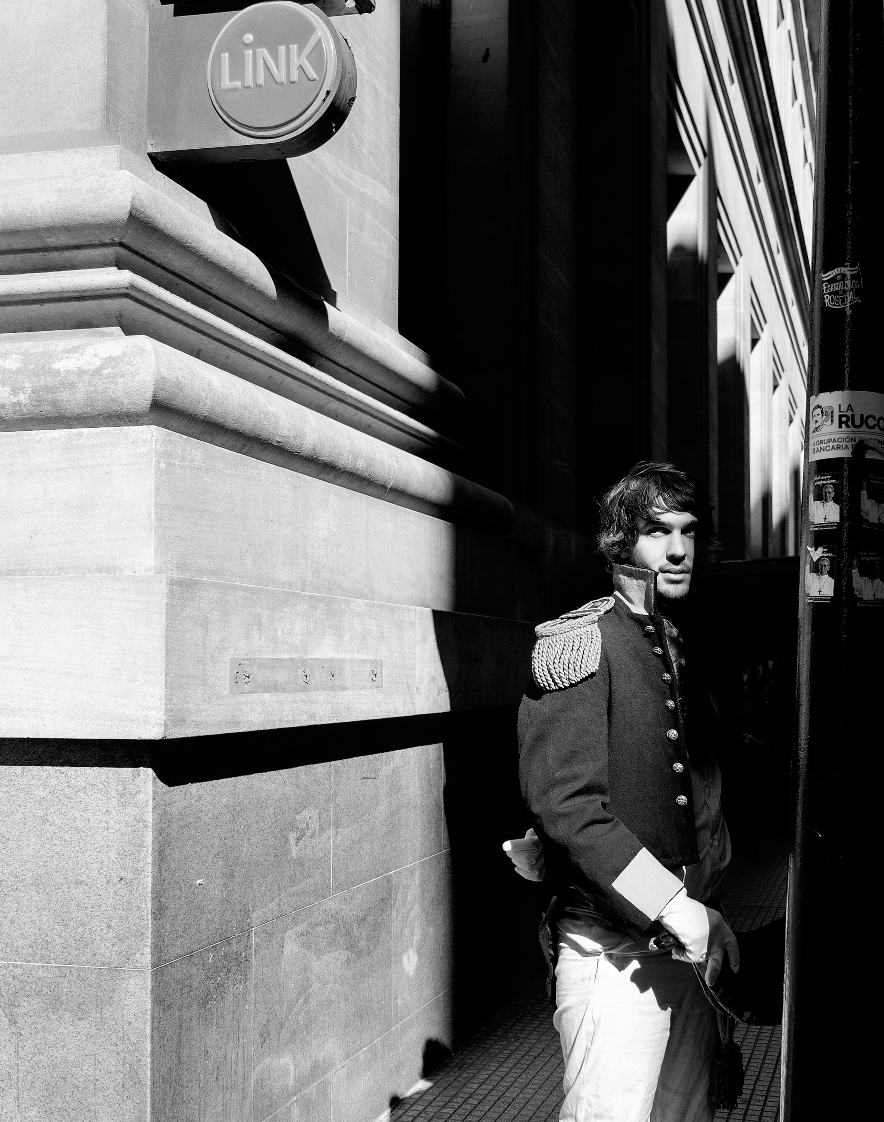 Black and white portrait of a man in historic attire on a Buenos Aires street.