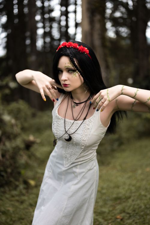 Free Woman in white dress in Costa Rican forest, adorned with red floral crown and vine accessories. Stock Photo