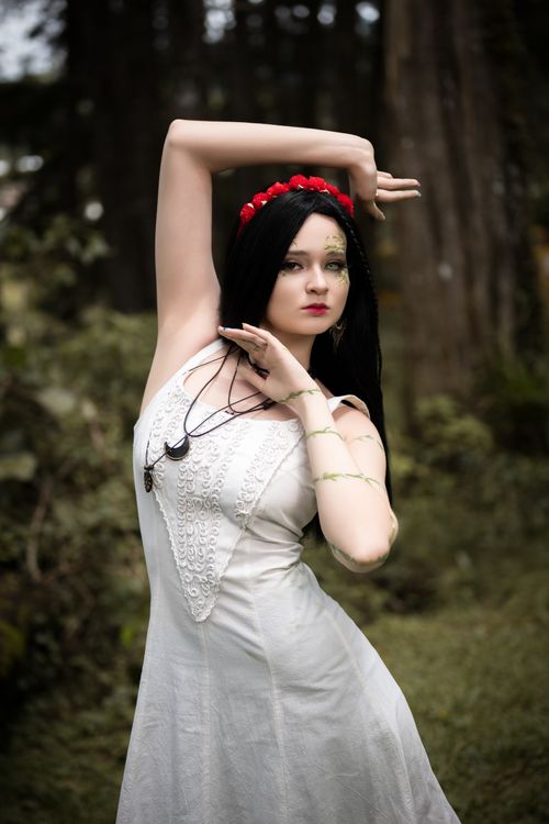 Free Captivating portrait of a woman in a white dress and floral crown amidst the lush Alajuela forest. Stock Photo