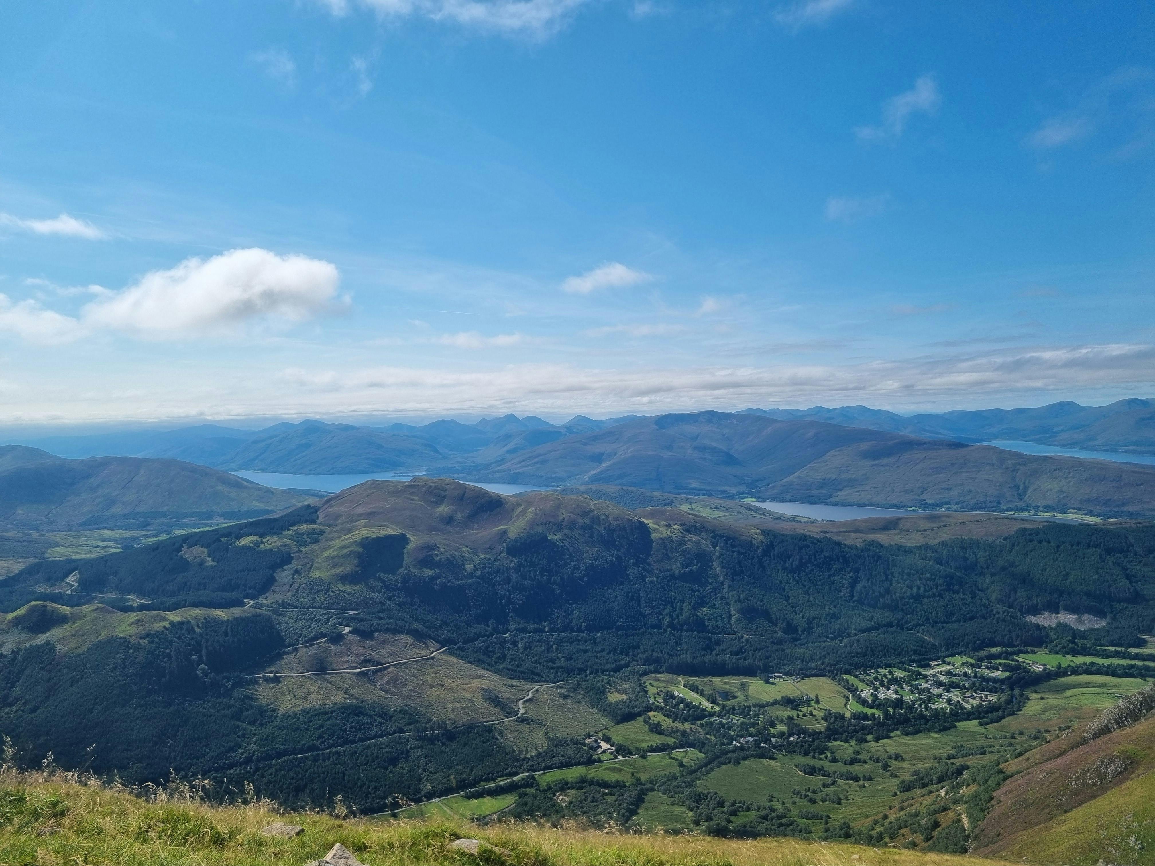 Panoramic view of Scottish Highland green hills under blue sky