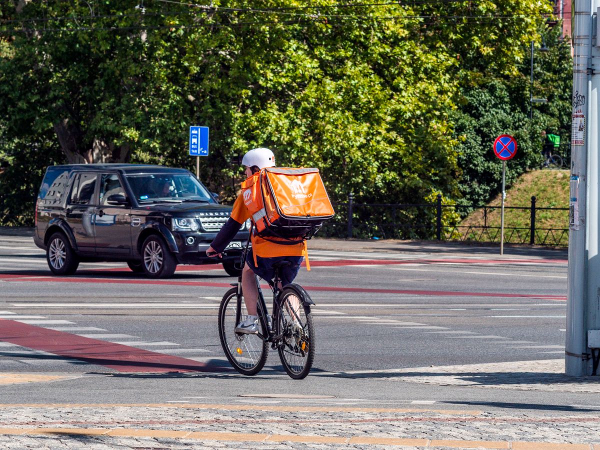 Bicycle courier crossing a city street