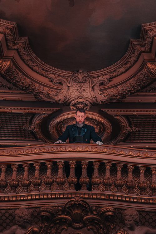Free Refined portrait of a man in an exquisite balcony with intricate historical architecture. Stock Photo