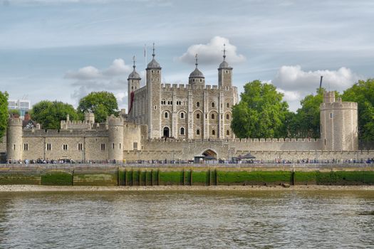 Scenic view of the iconic Tower of London from the River Thames on a bright day.