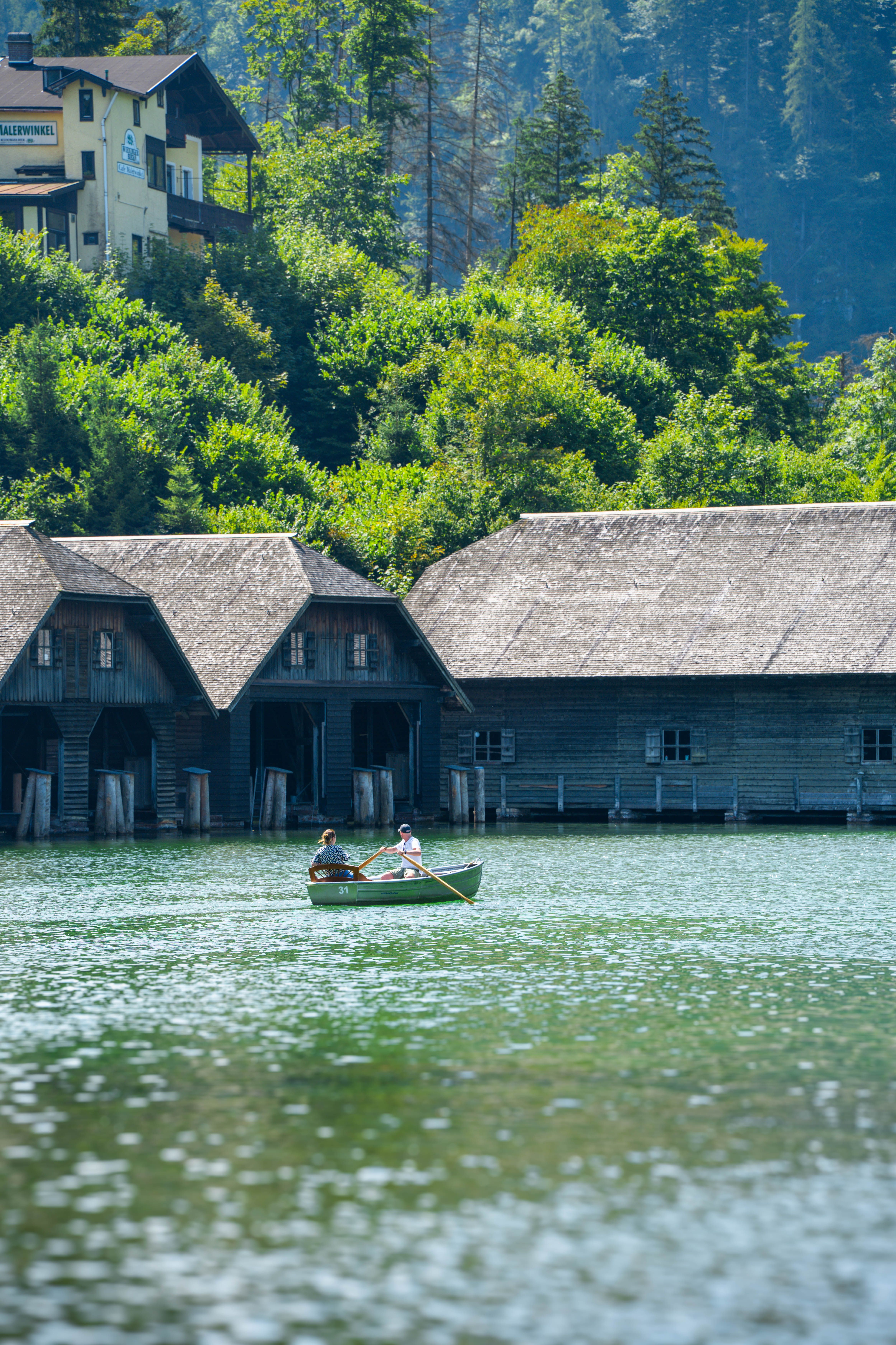 Scenic Boat Ride on Serene Lake Near Rustic Cabins · Free Stock Photo