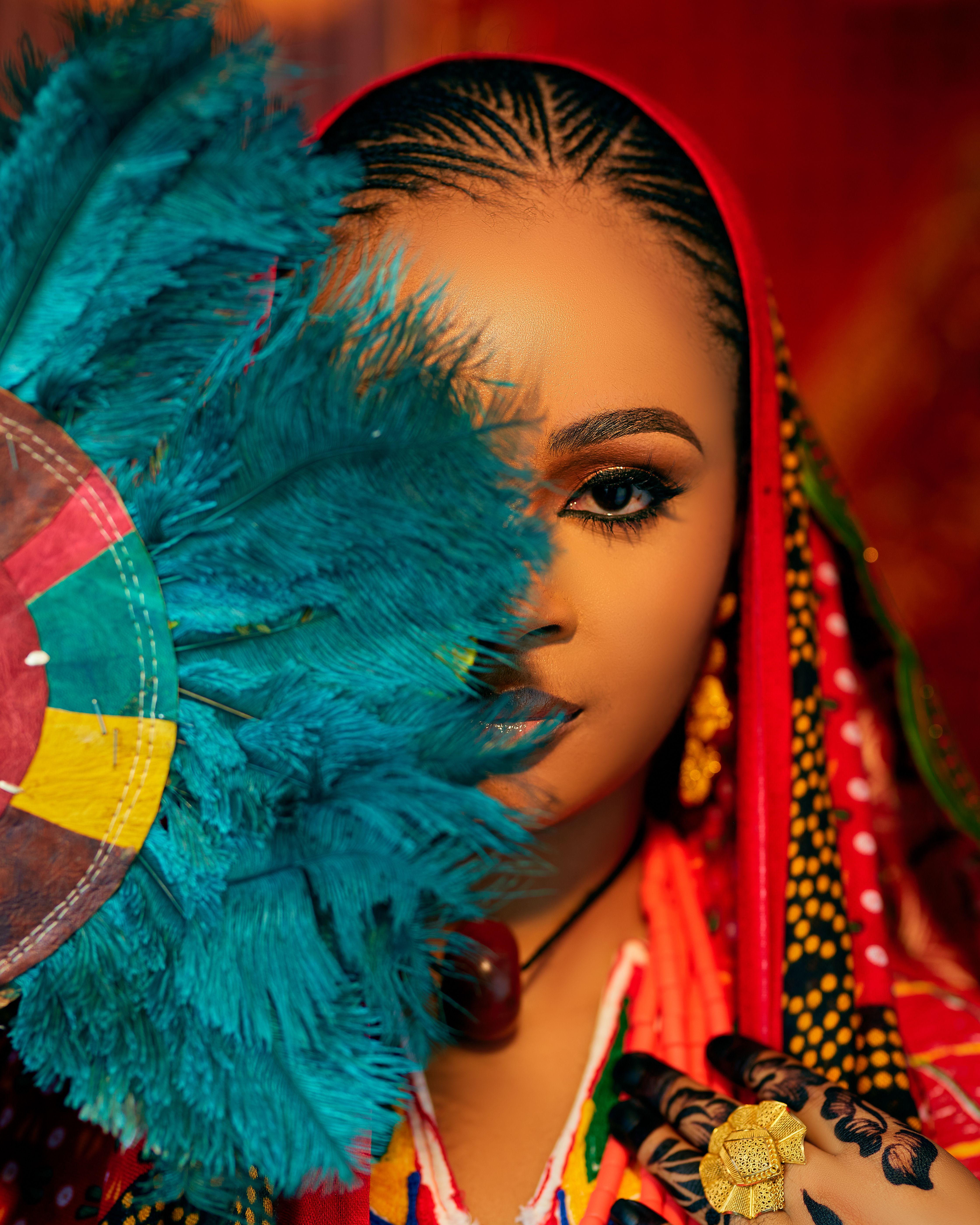 Colorful portrait showing a woman in traditional attire with a feathered fan.