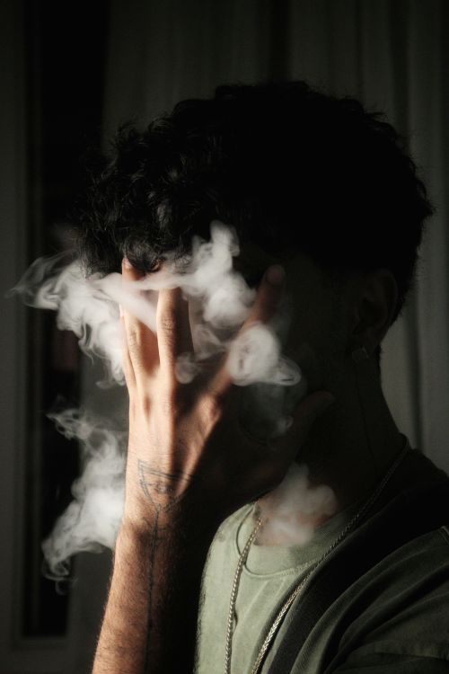Free Dramatic portrait of a person shrouded in smoke, conveying mystery and emotion. Stock Photo